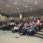 Large group of people listening to a presentation